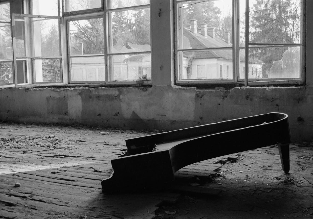 A haunting black and white image of a broken piano in an abandoned building in Rozdil, Ukraine.